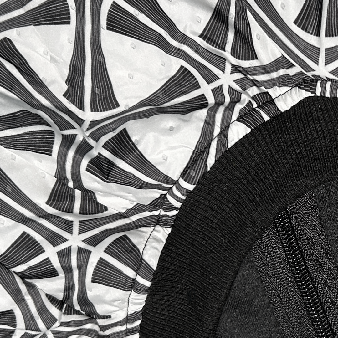 close up of the fabric and trim on a Black and white geometric print dog coat