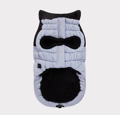 The underside of a quilted dog coat with a black fleece lining