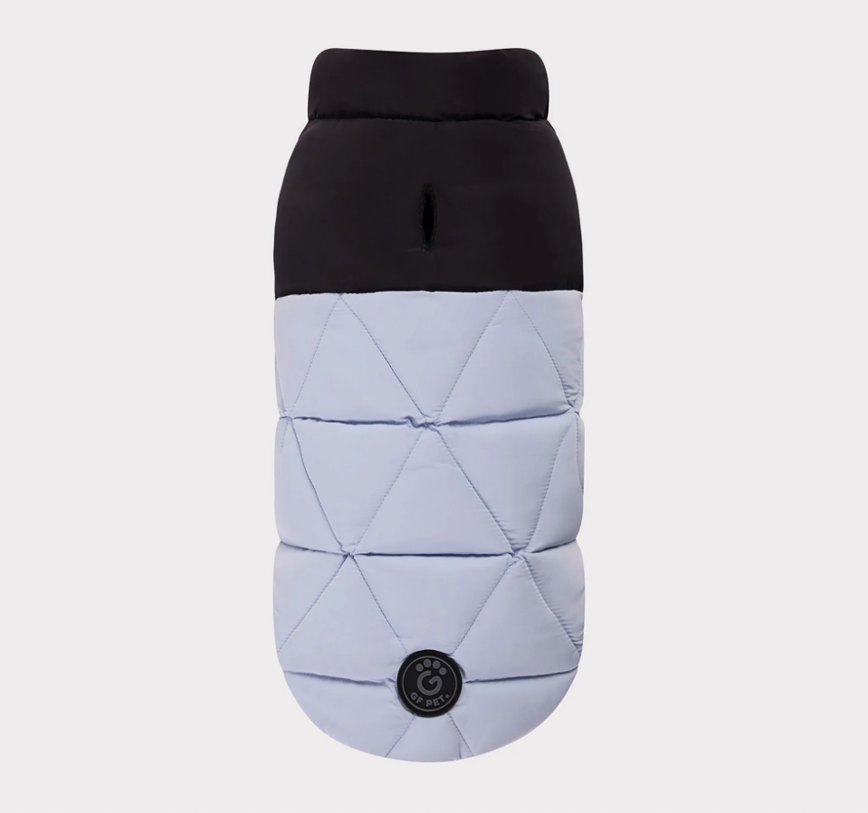Quilted dog coat with black top and light gray bottom on a white background