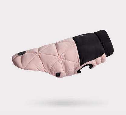 Side view of a pink quilted dog coat with black interior on a light gray background